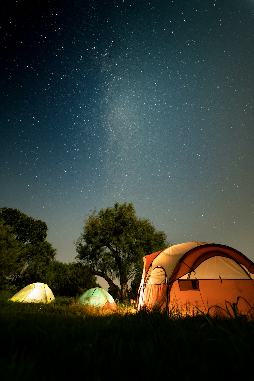 a couple of tents sitting on top of a lush green field