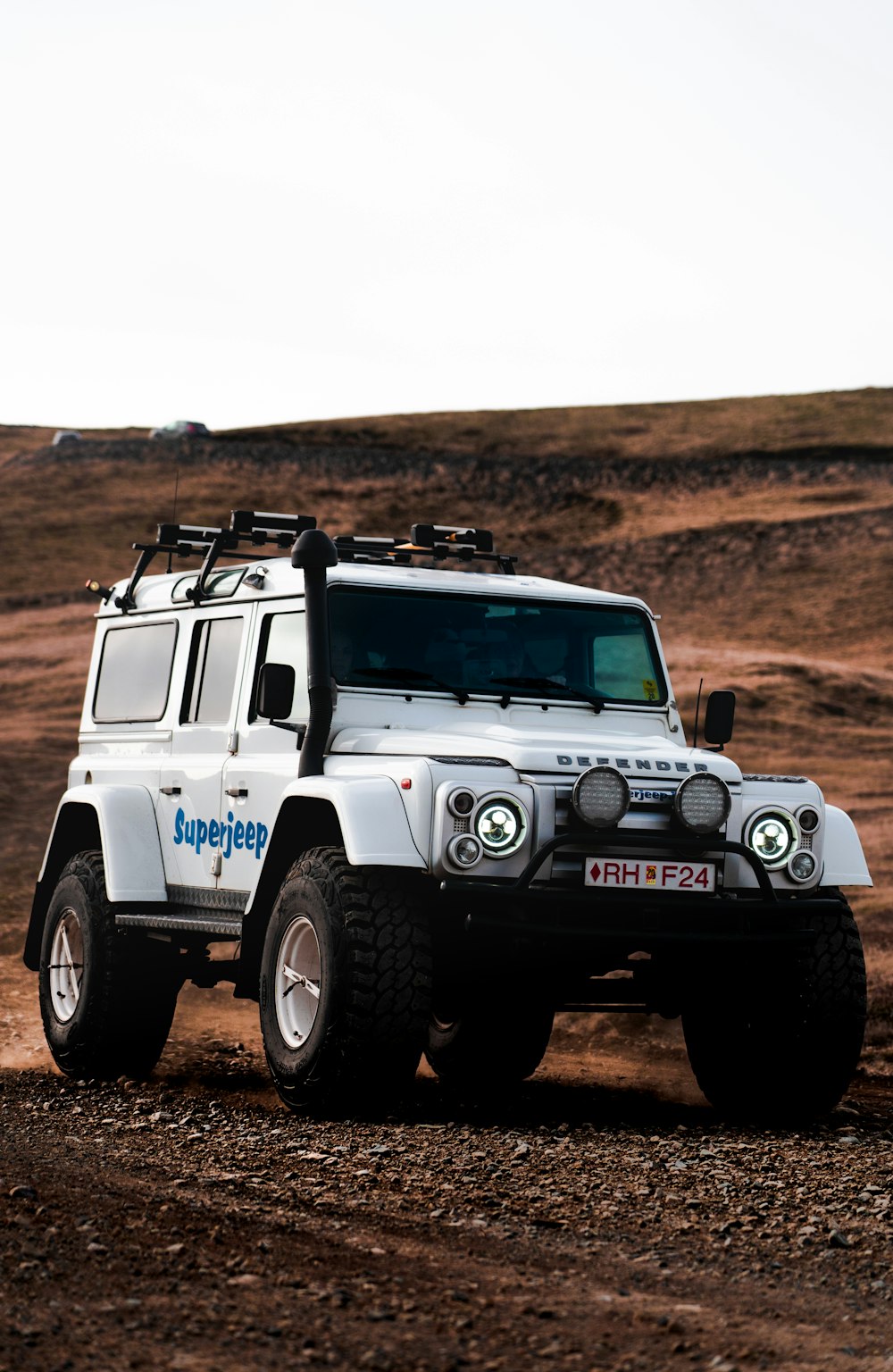 white and black jeep wrangler on dirt road during daytime