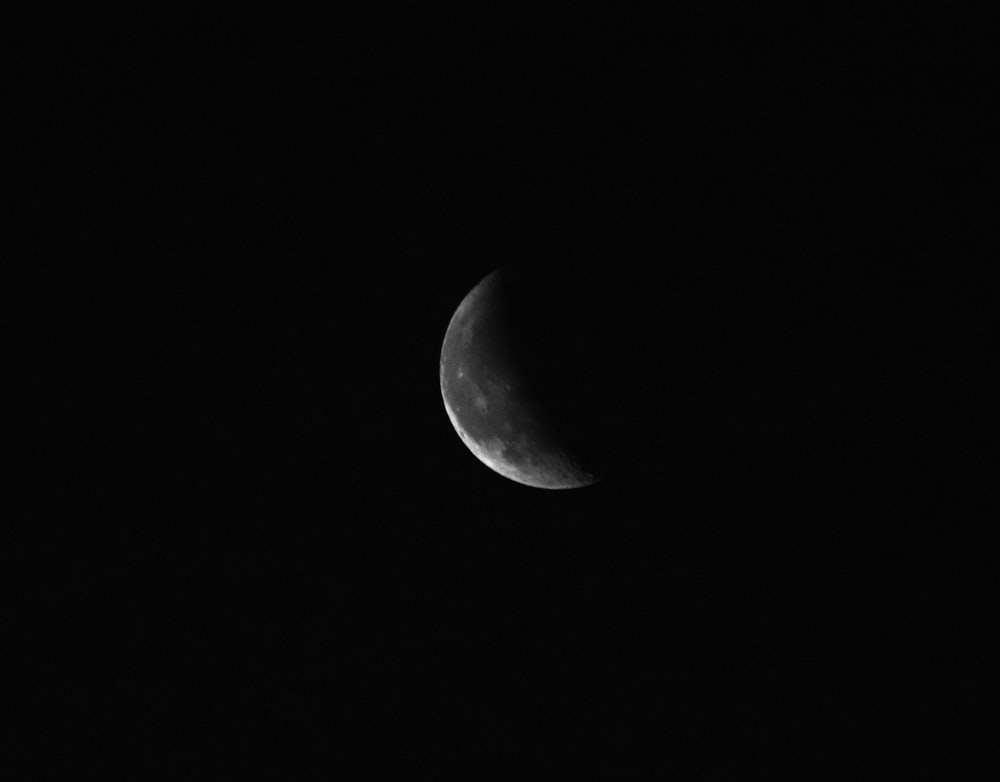 grayscale photo of moon in dark night sky