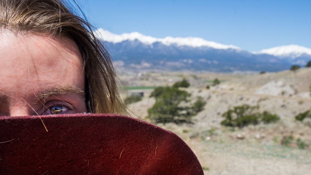 woman in red shirt standing on brown field during daytime