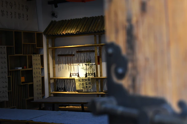 A serene artist's studio with natural light filtering through bamboo blinds, showcasing traditional Chinese paintings.