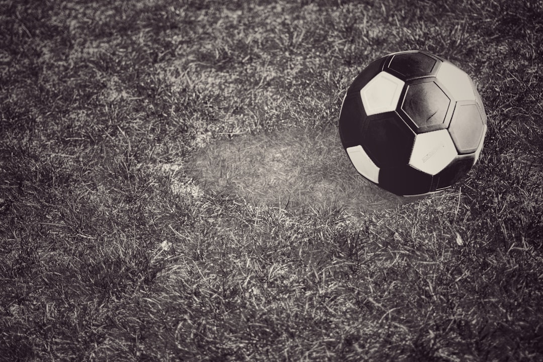 black and yellow soccer ball on green grass field