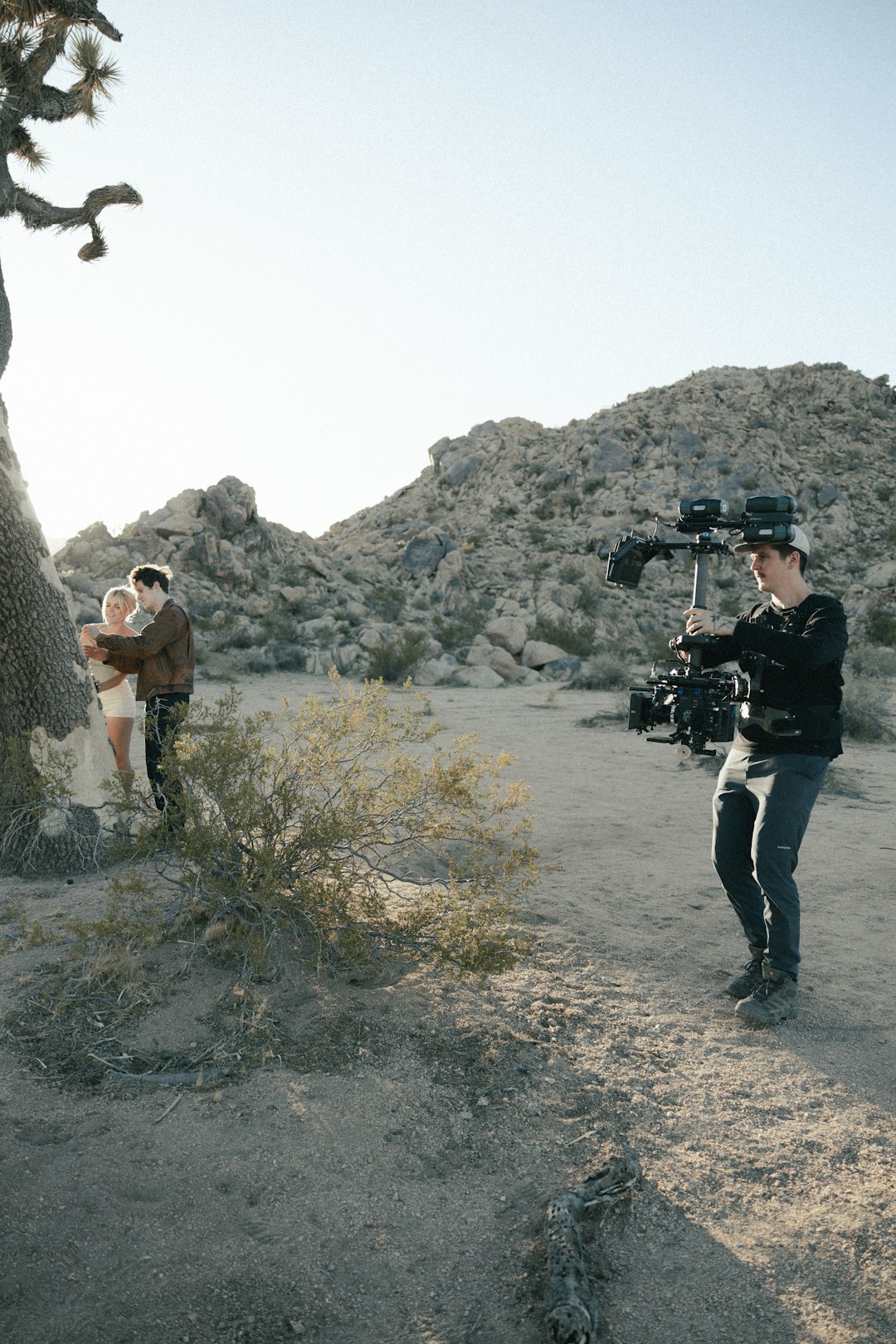 man in black jacket and black pants holding black camera taking photo of rock formation during