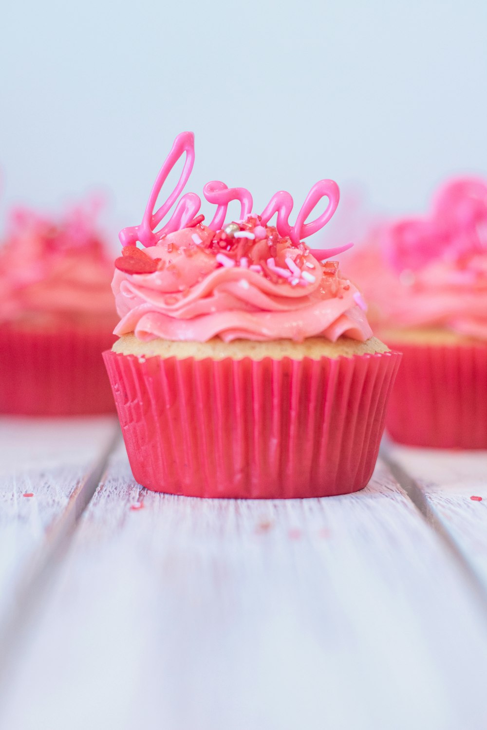 위에 분홍색 장식이 있는 분홍색 컵케이크