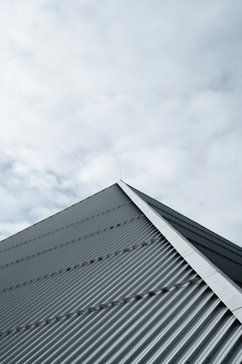 white concrete building under white clouds during daytime