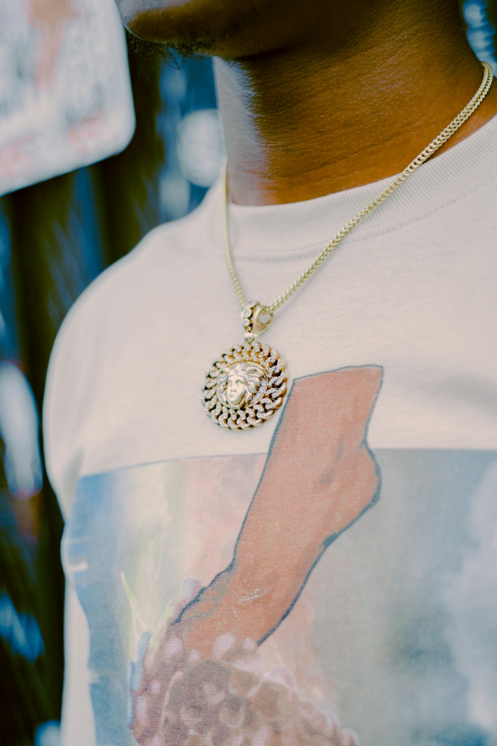 person wearing silver necklace and white shirt