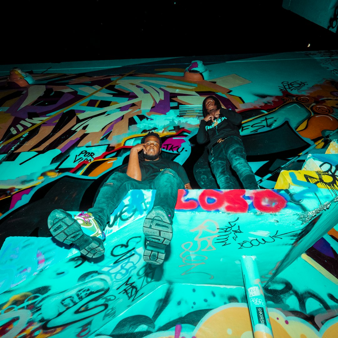 man and woman lying on graffiti wall art