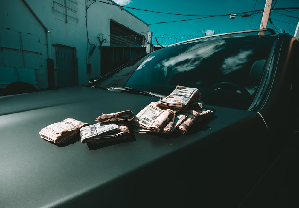 carro preto estacionado ao lado do edifício branco durante o dia