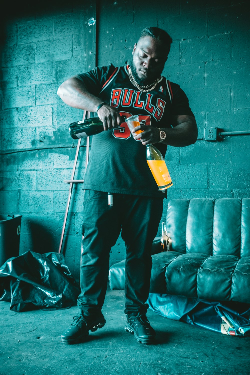 man in black and white long sleeve shirt and pants holding orange and black power tool