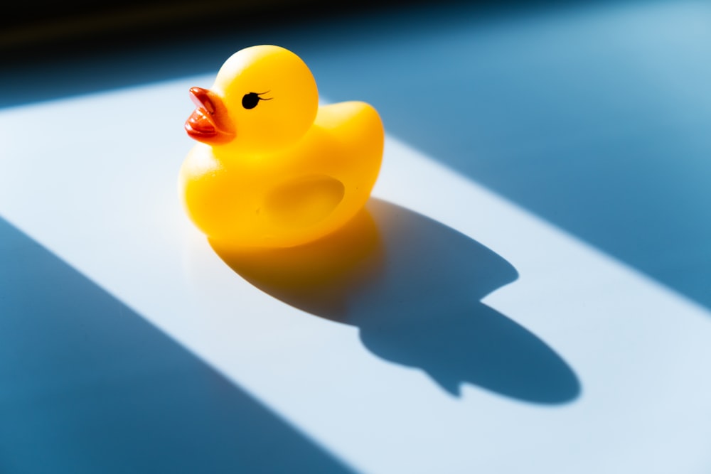 yellow rubber duck on white table