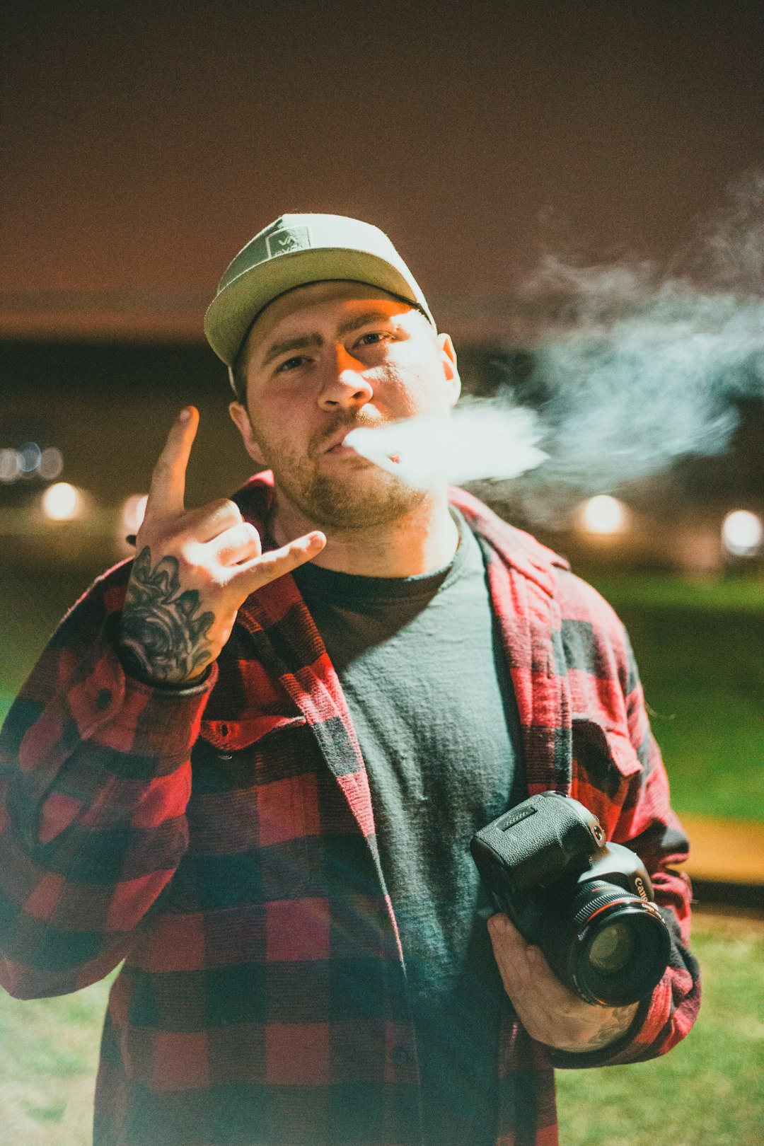 man in red and black plaid shirt smoking cigarette