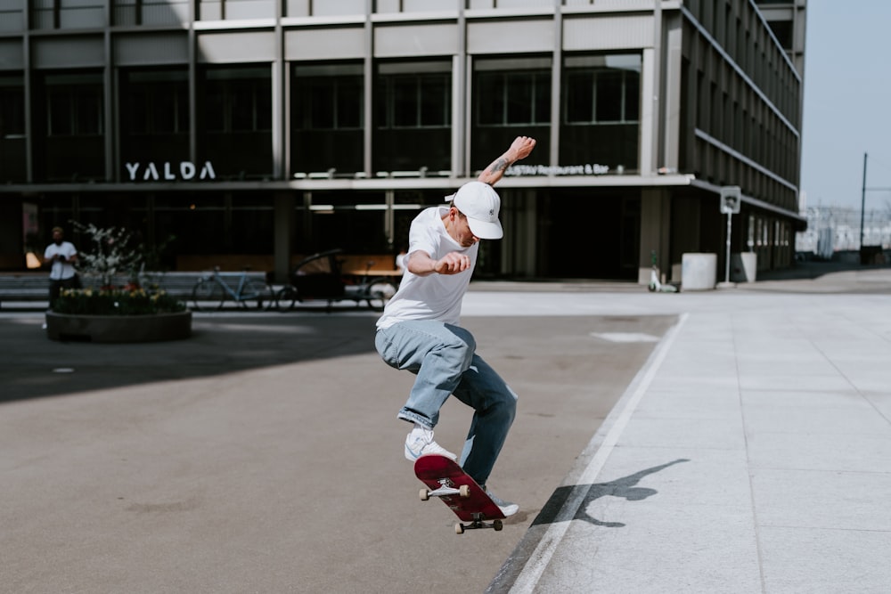 man in white shirt and white pants playing skateboard during daytime