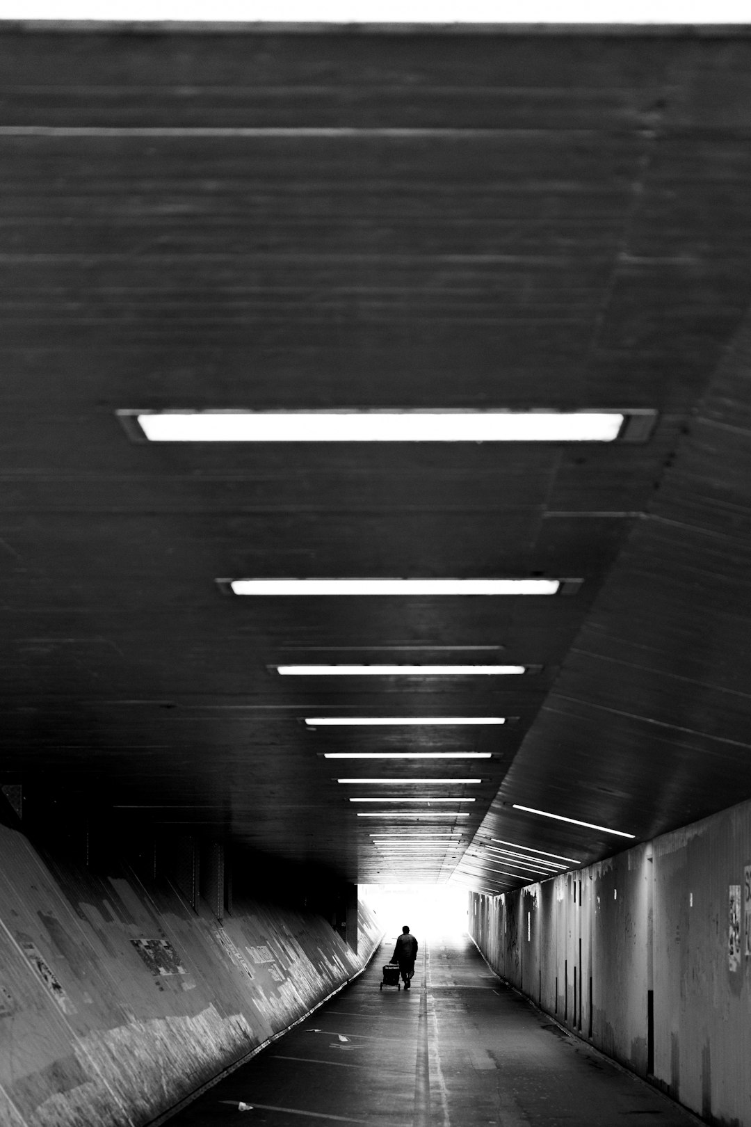 grayscale photo of tunnel with lights