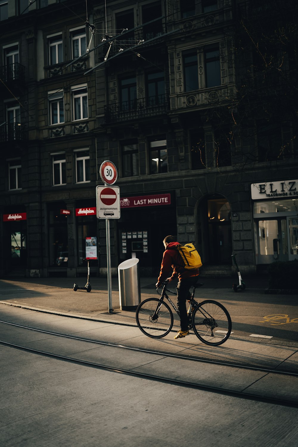 man in yellow jacket riding bicycle on road during daytime