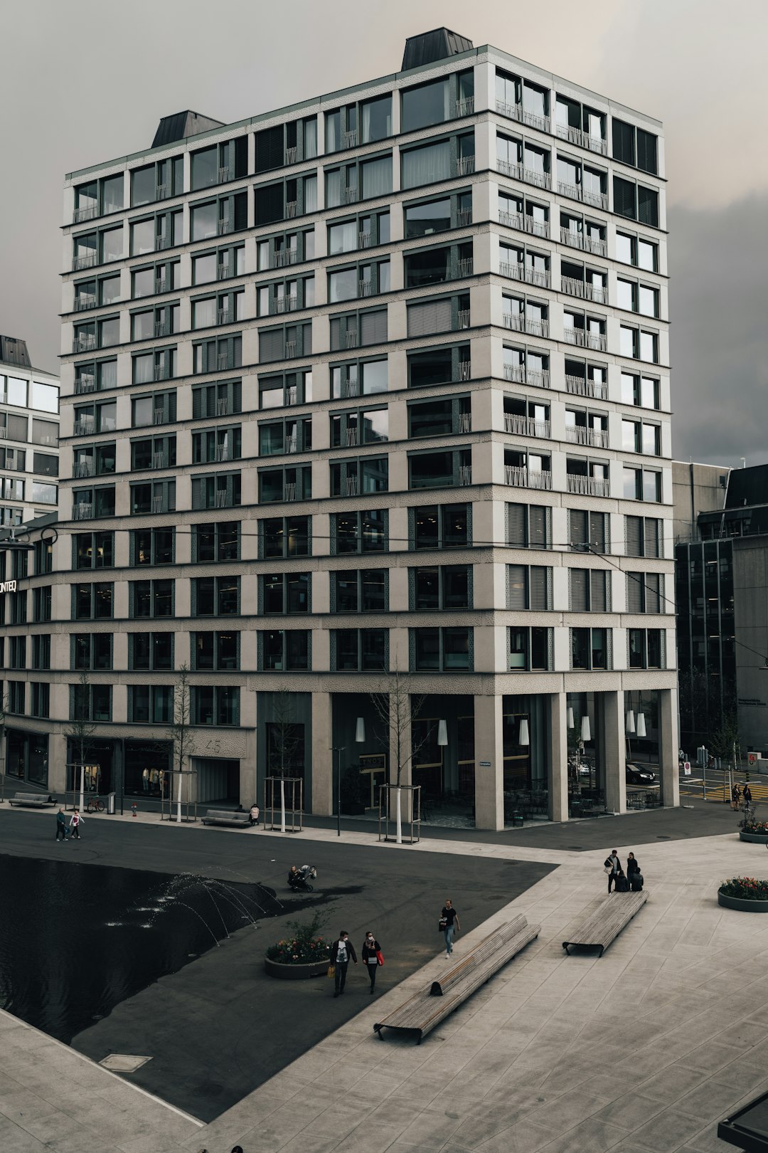 people walking on sidewalk near brown concrete building during daytime