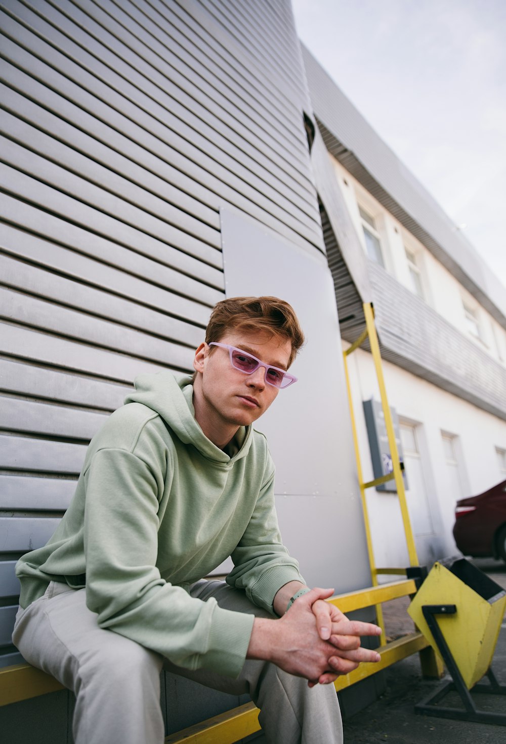 man in green sweater sitting on yellow chair