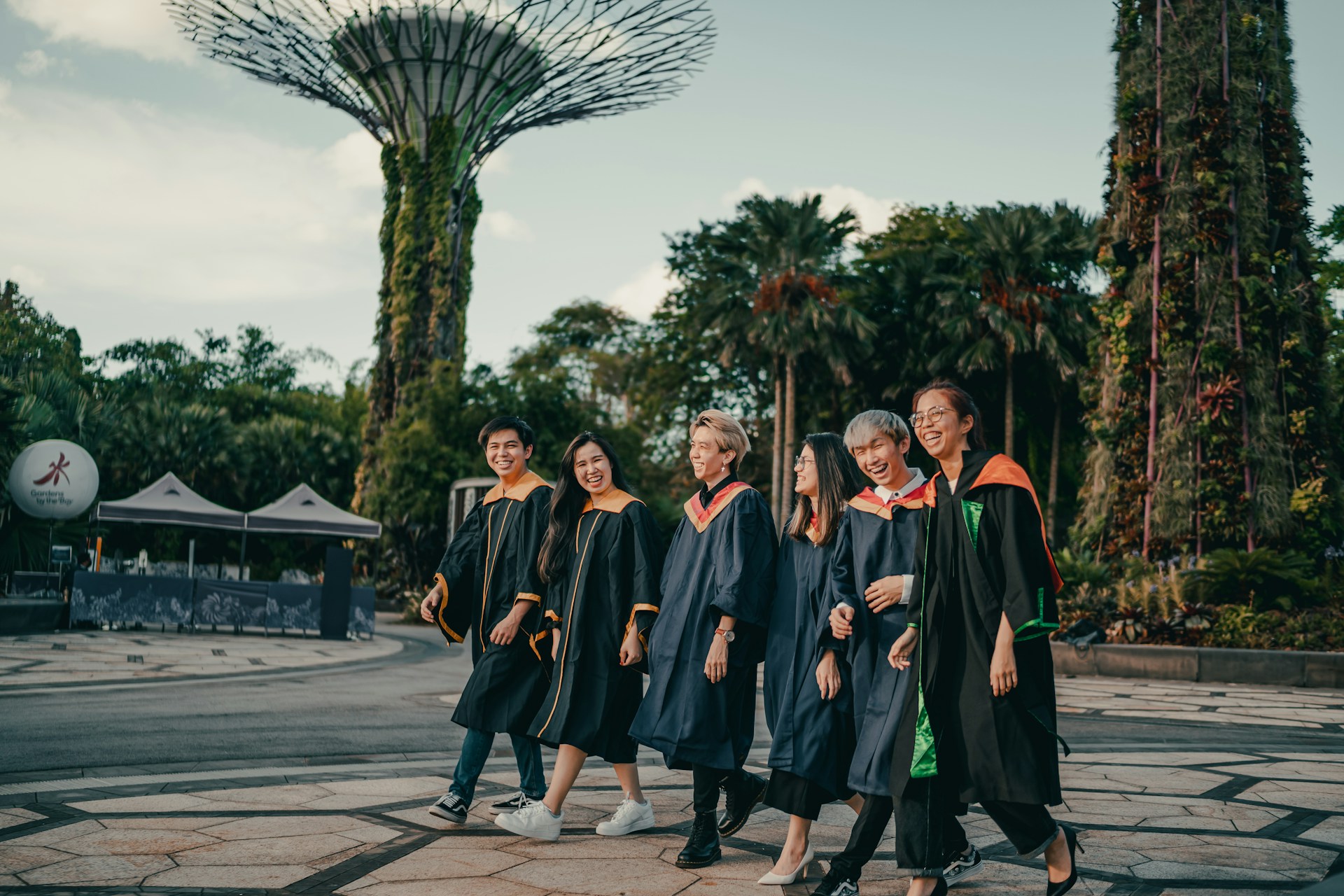 group of people in black and red academic dress standing on gray concrete pavement during daytime