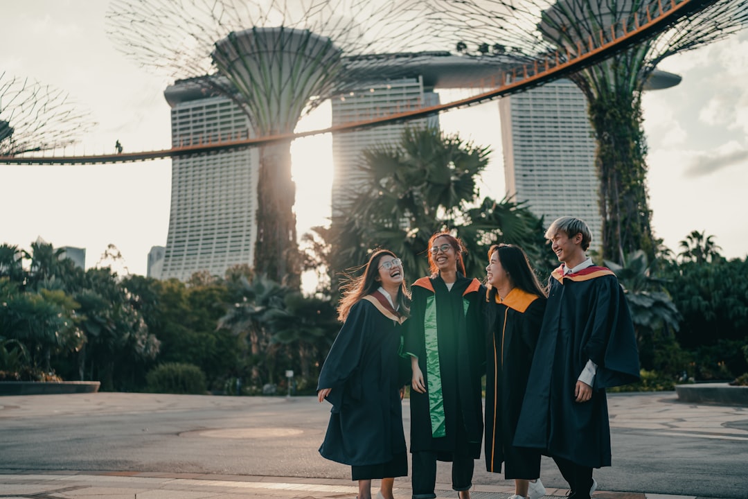 people in green and red academic dress standing on gray concrete pavement during daytime