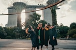 woman in black academic dress standing on gray concrete floor during daytime