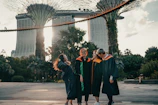 woman in black academic dress standing on gray concrete floor during daytime