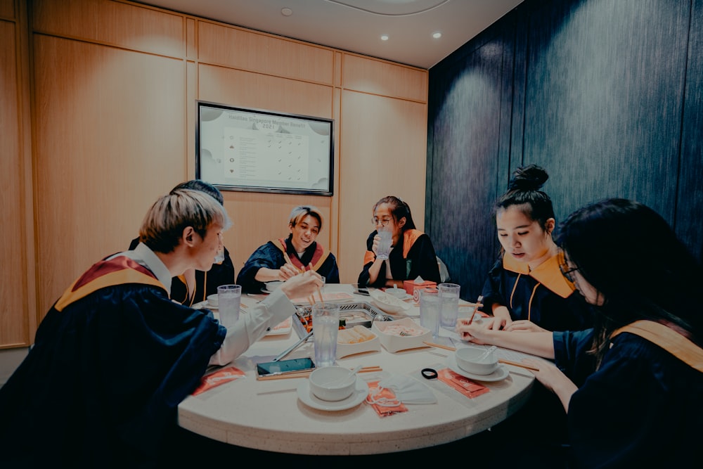 grupo de personas sentadas alrededor de la mesa