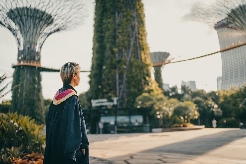 woman in black coat standing on road during daytime