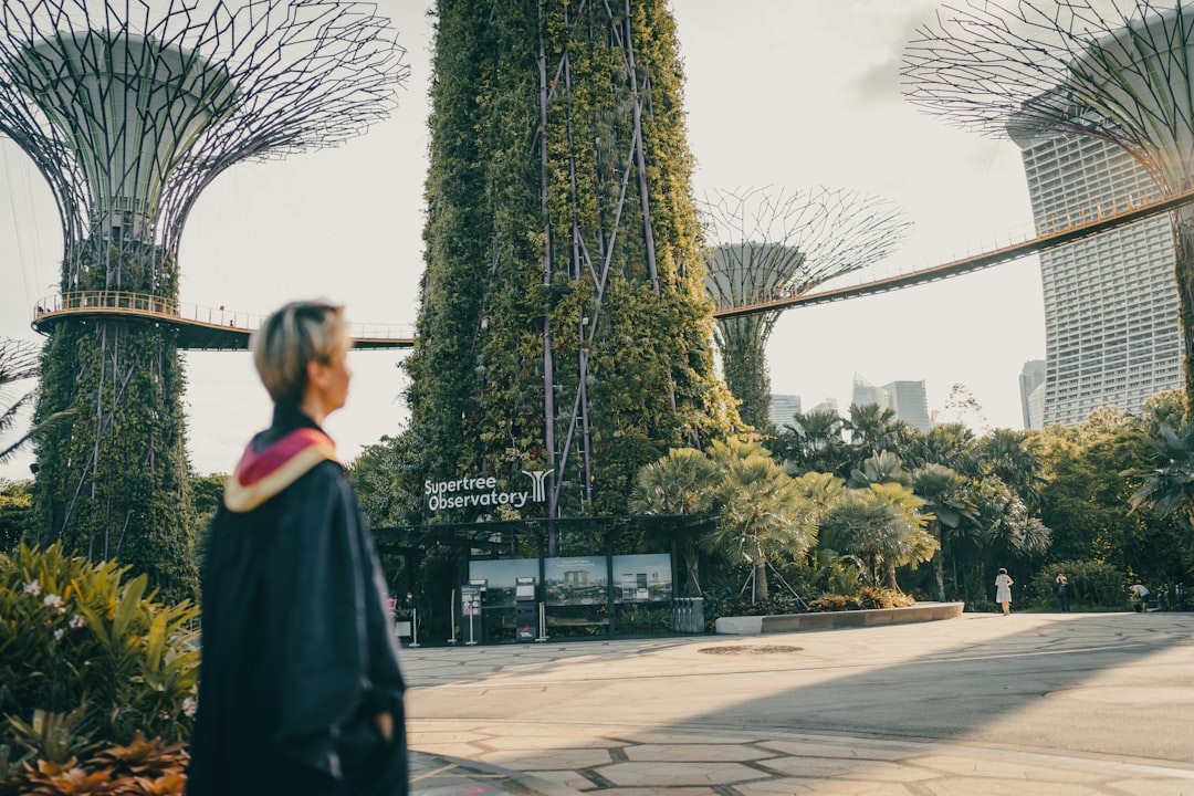 woman in black and white school uniform standing on sidewalk during daytime