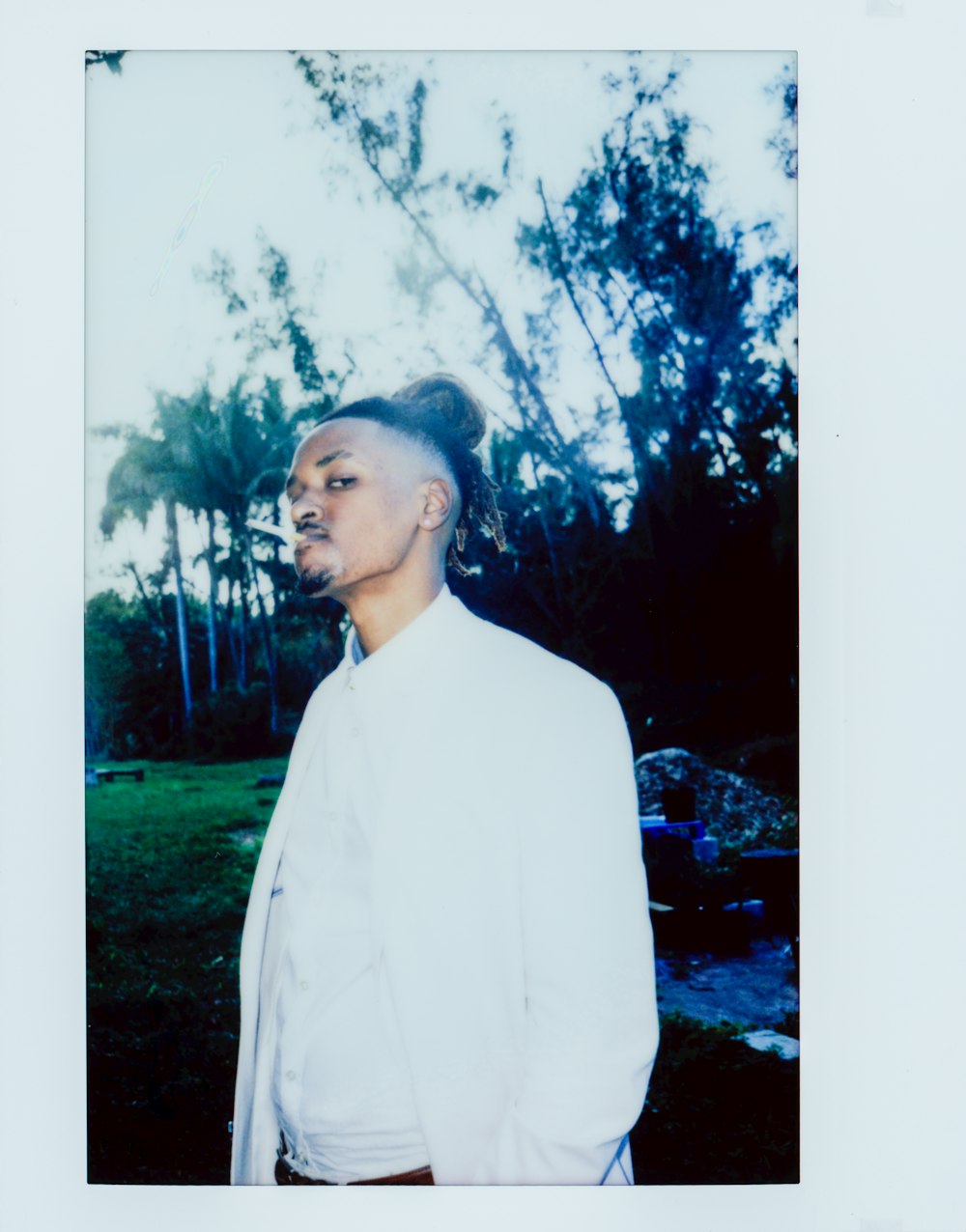 woman in white long sleeve shirt standing near green trees during daytime