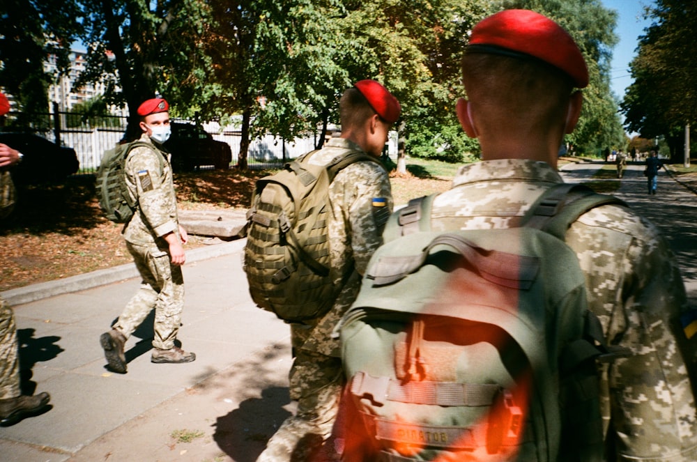 men in camouflage uniform standing on ground during daytime