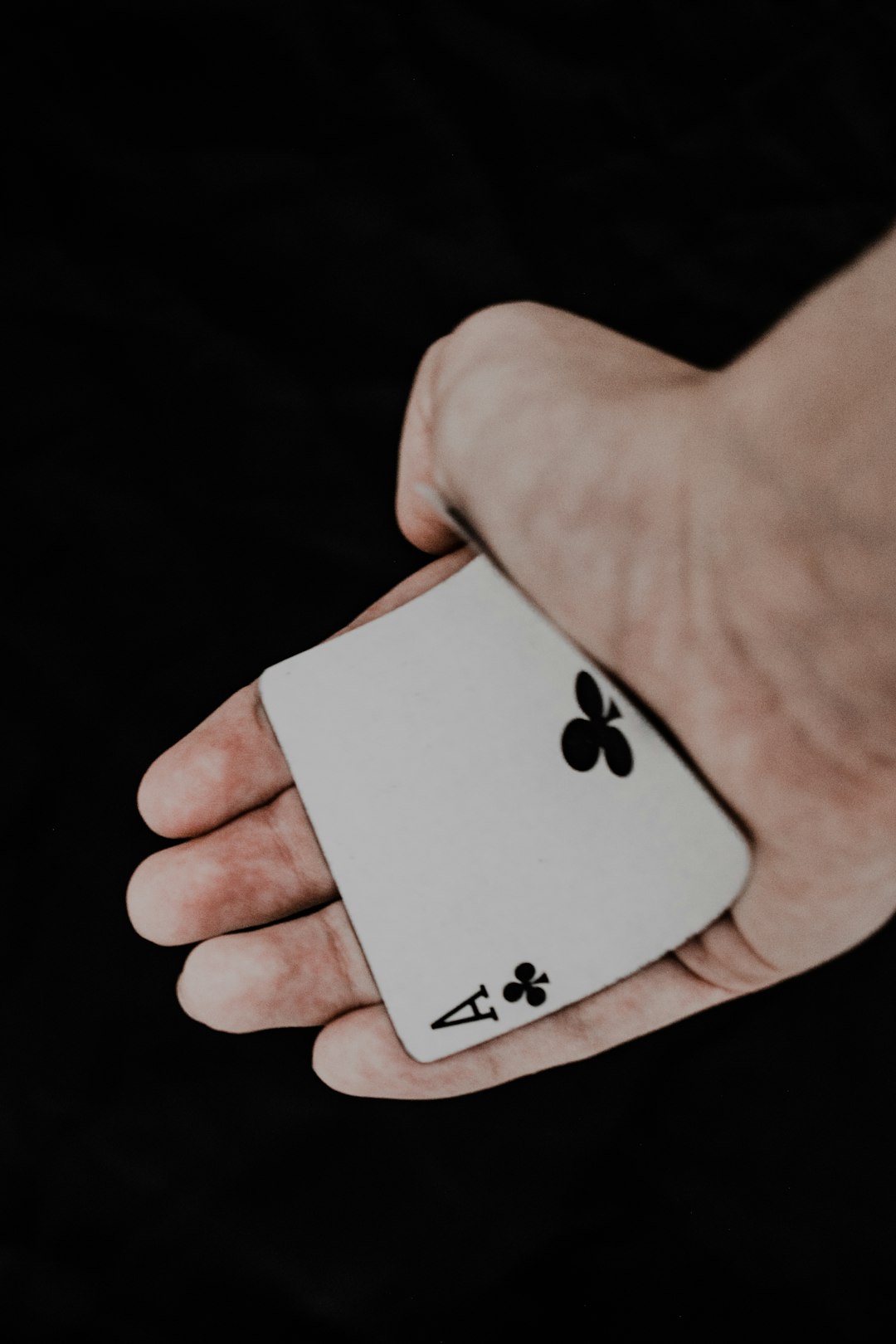 person holding 2 of spade playing card