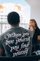 man in gray crew neck t-shirt sitting beside woman in black shirt