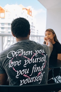 man in gray crew neck t-shirt sitting beside woman in black shirt