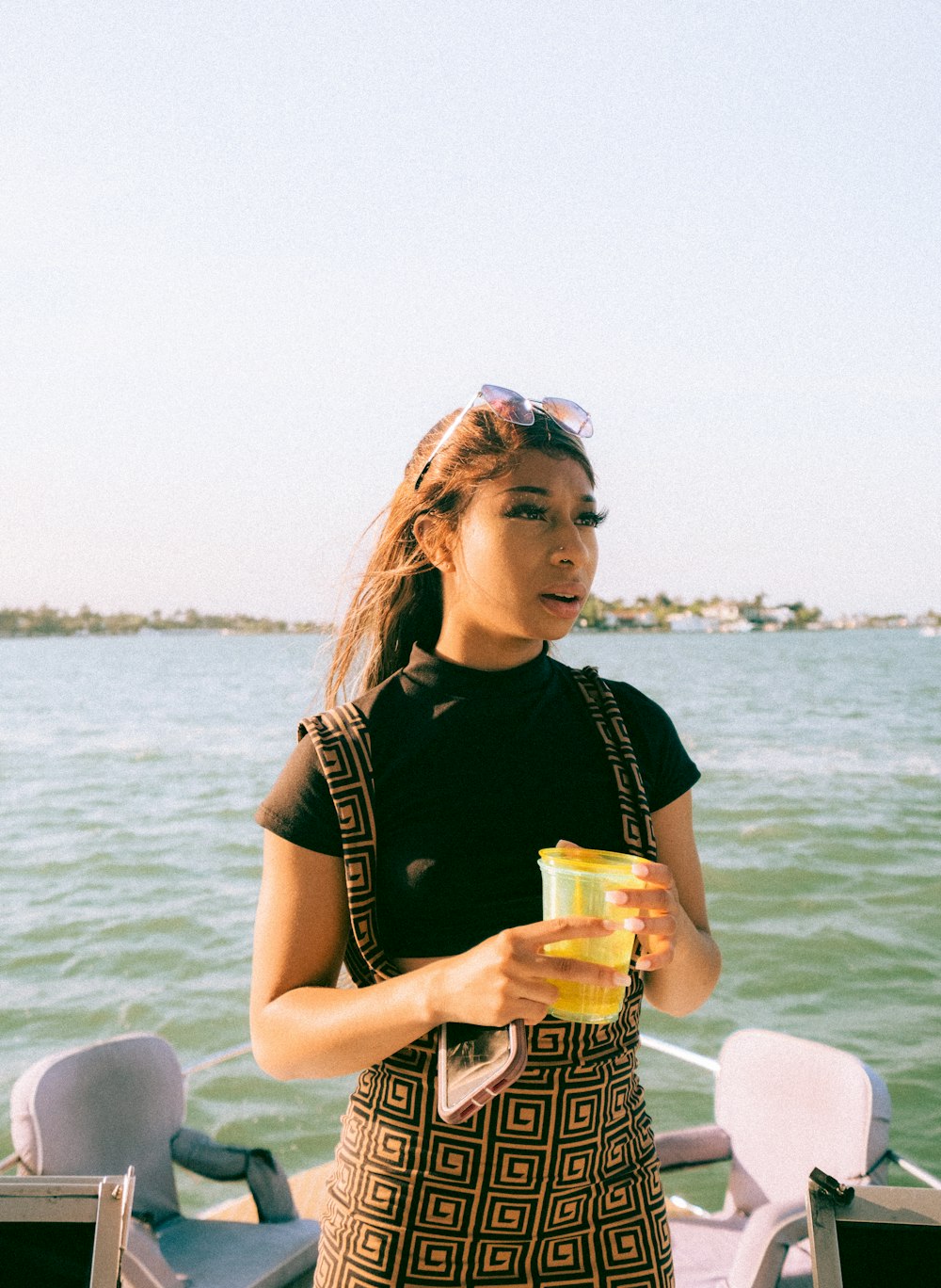 woman in black tank top holding clear drinking glass