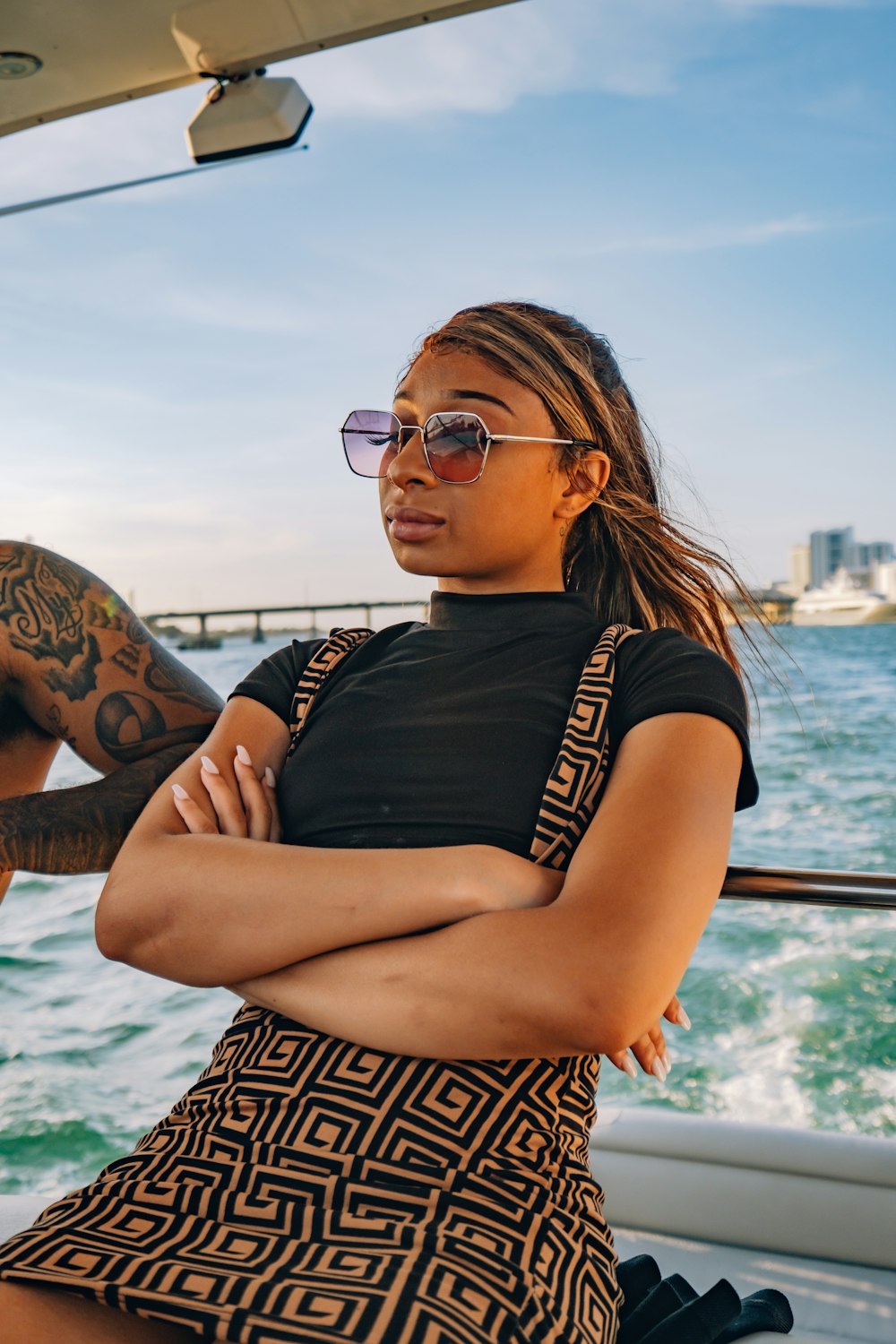 woman in black shirt wearing black framed eyeglasses sitting on boat during daytime