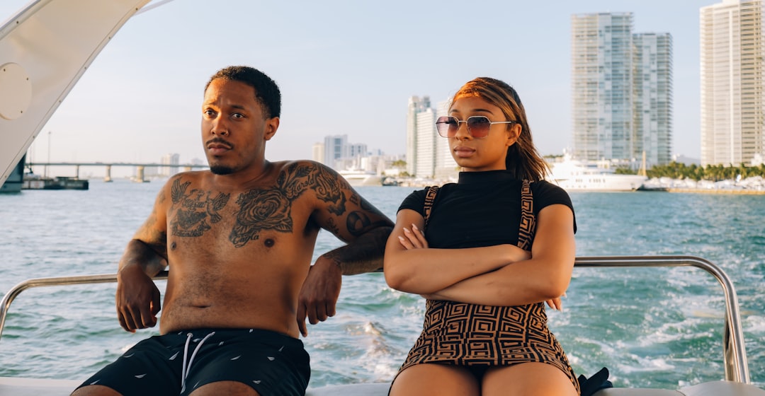 man and woman in black tank top and blue denim shorts standing on water during daytime