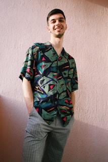 A relaxed model wearing an MPB-themed t-shirt, standing against a soft pastel wall with subtle musical motifs.