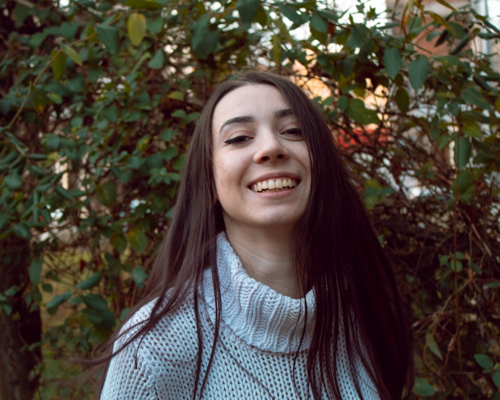 woman in white and blue plaid shirt smiling