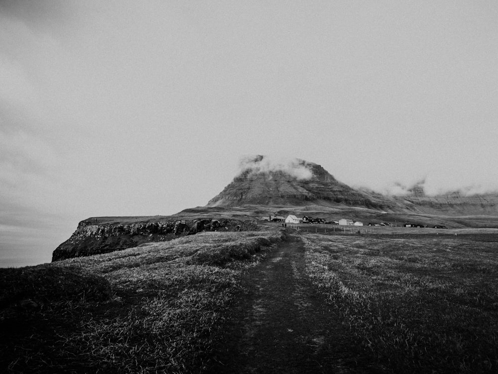 grayscale photo of mountain under cloudy sky