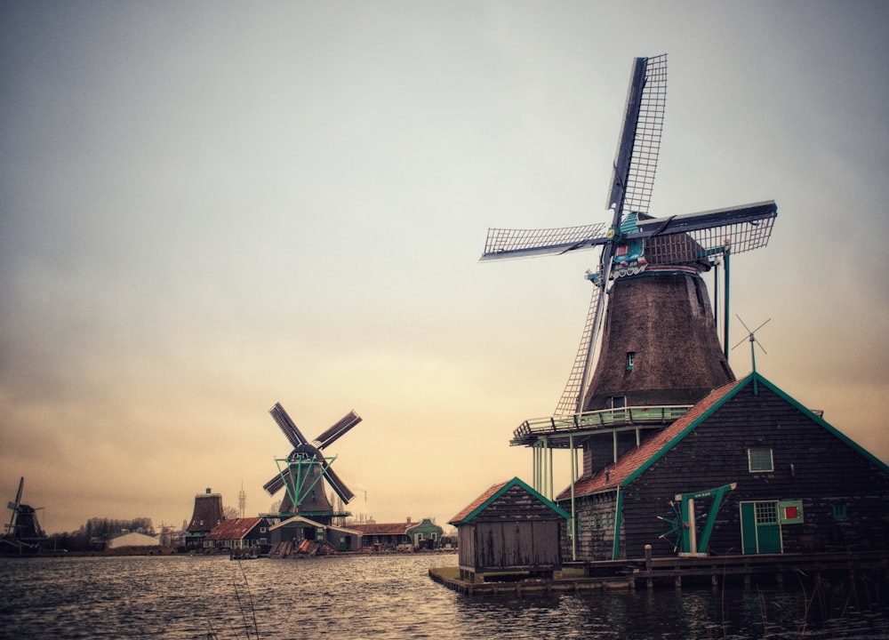 a group of windmills sitting on top of a body of water