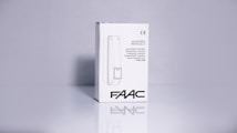 A product packaging box with a white background displaying the brand name 'FAAC' and the text 'Adjustable Photocells' along with translations in multiple languages. The image features clean lines and a minimalistic design with the CE certification mark visible.