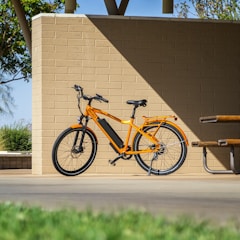 A colorful electric children's bike resting in a sunny park.