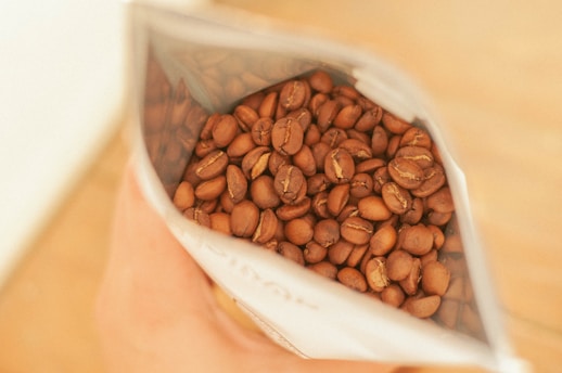brown coffee beans in white ceramic bowl