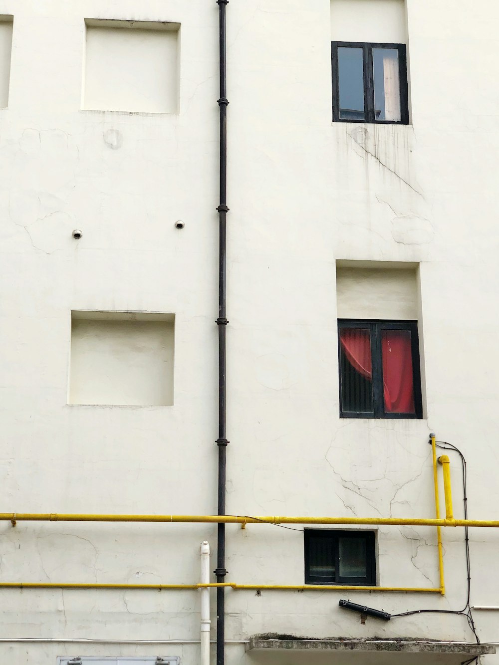 white concrete building with red window