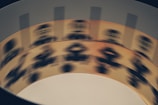 A rotating zoetrope reveals a sequence of black silhouette images on a beige strip, creating the illusion of motion. The blurry appearance indicates rapid movement.