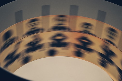 A rotating zoetrope reveals a sequence of black silhouette images on a beige strip, creating the illusion of motion. The blurry appearance indicates rapid movement.