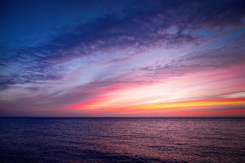 corpo d'acqua sotto cielo blu durante il tramonto