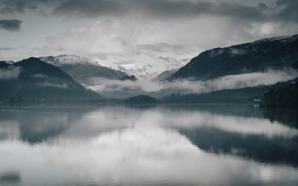 Specchio d'acqua vicino alla montagna sotto il cielo nuvoloso durante il giorno