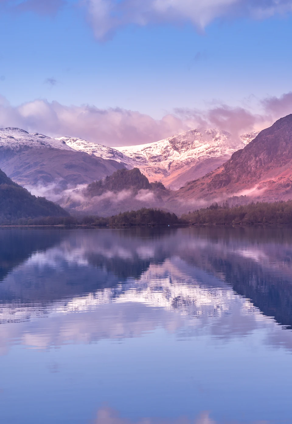 Serene mountain landscape with a large lake at its center surrounded by snow-capped mountains