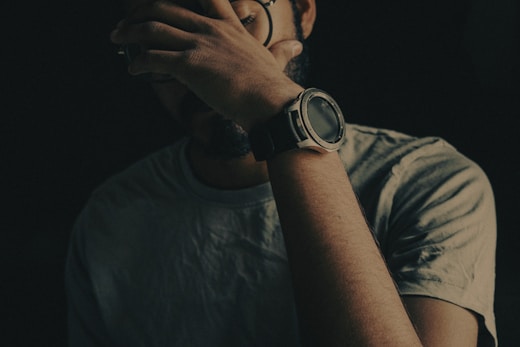 man in black crew neck shirt wearing black round watch