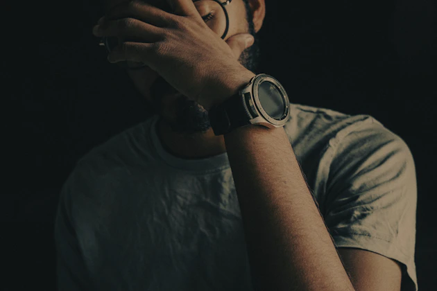 man in black crew neck shirt wearing black round watch